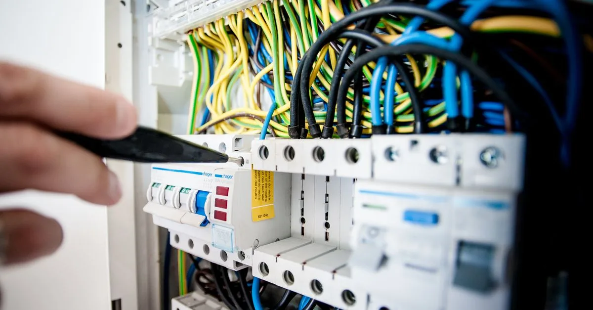 Geöffneter Elektroverteiler mit Leitungen und Sicherungen